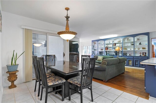dining space featuring built in shelves and light tile patterned flooring