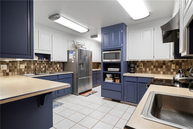 kitchen featuring blue cabinets, stainless steel appliances, and a sink