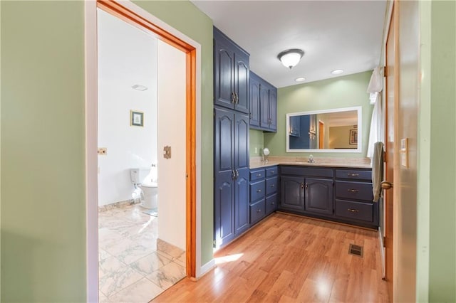 bathroom featuring recessed lighting, visible vents, vanity, wood finished floors, and baseboards