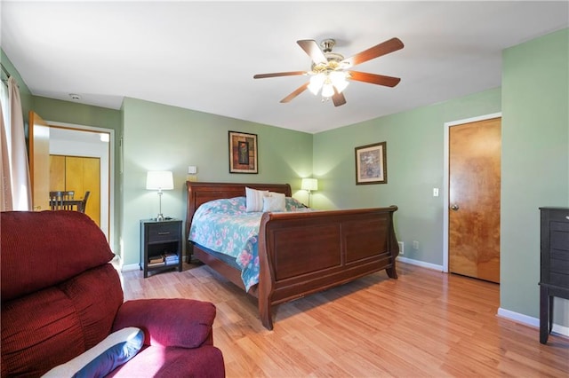 bedroom with light wood finished floors, ceiling fan, and baseboards