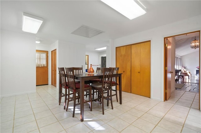 dining room featuring an inviting chandelier, visible vents, baseboards, and light tile patterned floors
