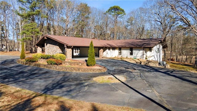 exterior space featuring aphalt driveway and stone siding