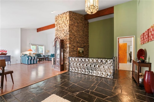 living area featuring high vaulted ceiling, beamed ceiling, and wood finished floors