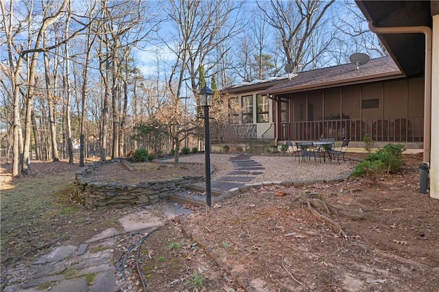view of yard with a sunroom and a patio area