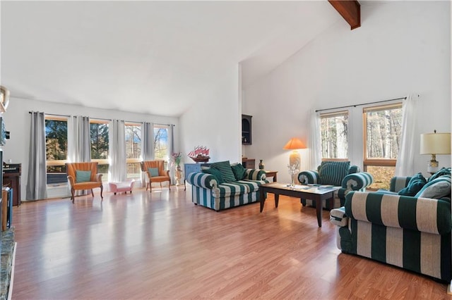 living room featuring light wood-style flooring, high vaulted ceiling, and beamed ceiling