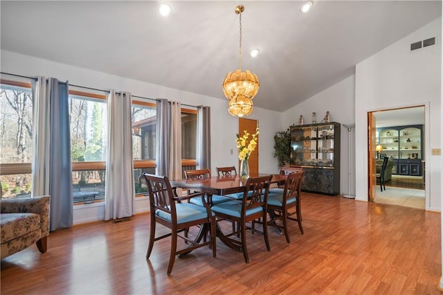 dining room featuring recessed lighting, visible vents, light wood-style floors, vaulted ceiling, and a chandelier
