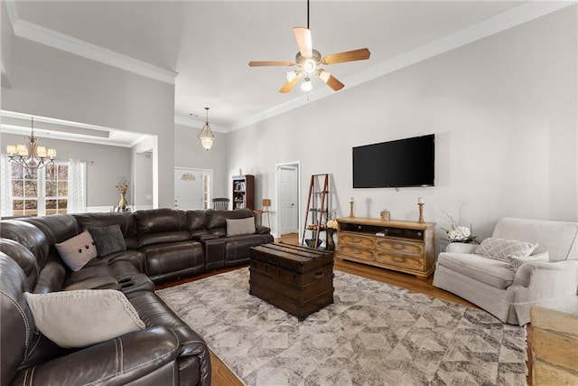 living room with ornamental molding, wood finished floors, and ceiling fan with notable chandelier