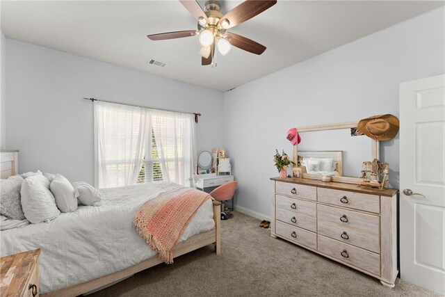 bedroom with light carpet, ceiling fan, visible vents, and baseboards