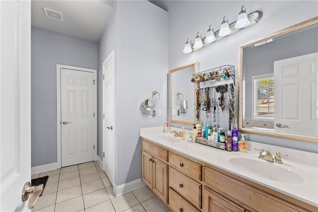 bathroom featuring double vanity, visible vents, a sink, and tile patterned floors