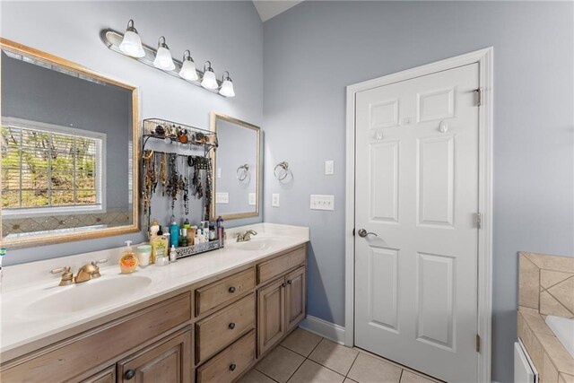 bathroom featuring double vanity, tile patterned flooring, a sink, and a bath