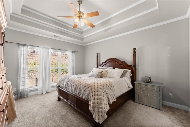bedroom featuring a tray ceiling, light colored carpet, visible vents, ornamental molding, and baseboards