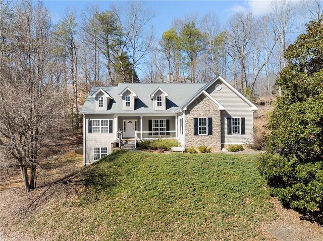 view of front of house featuring stone siding, a porch, and a front yard