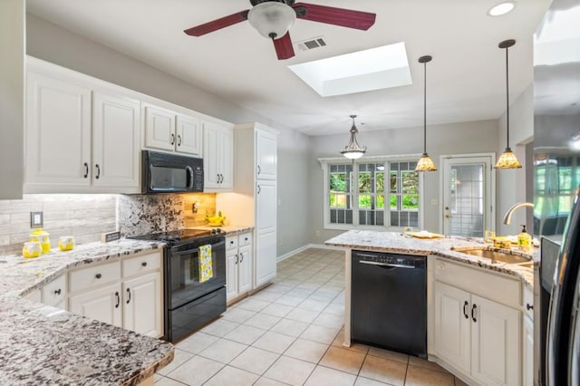 kitchen with a sink, visible vents, white cabinets, black appliances, and pendant lighting