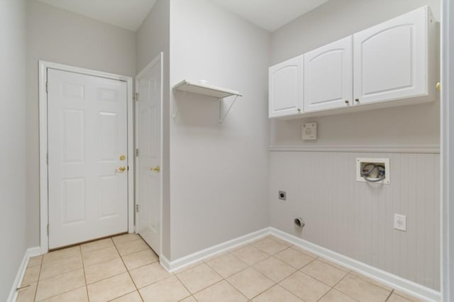 laundry room with light tile patterned floors, hookup for a washing machine, cabinet space, electric dryer hookup, and baseboards