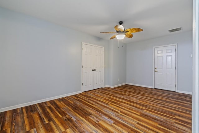 unfurnished room featuring ceiling fan, dark wood-type flooring, visible vents, and baseboards