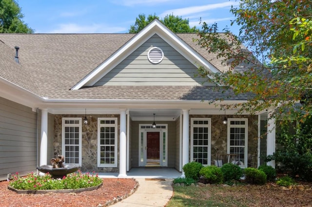 view of front of home featuring stone siding and roof with shingles