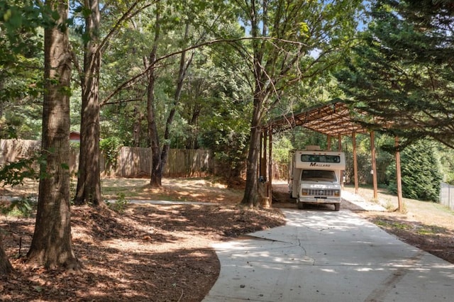 exterior space with driveway, fence, and a carport