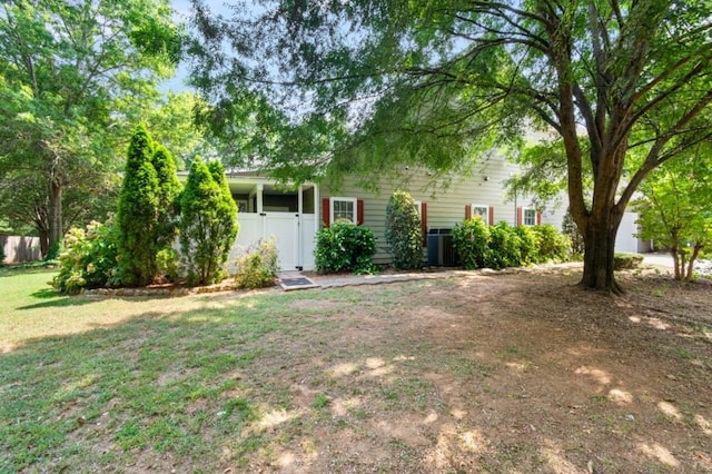 view of front facade with fence, central AC, and a front yard