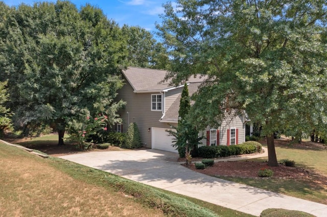 view of front of property with driveway, an attached garage, and a front yard