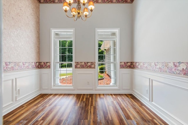 doorway with a chandelier, wainscoting, and wood finished floors