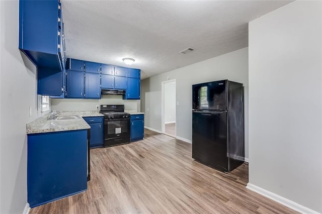 kitchen featuring light wood-style floors, blue cabinetry, black appliances, under cabinet range hood, and a sink