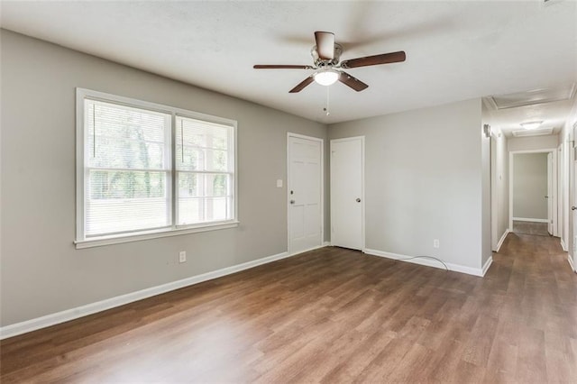 spare room with baseboards, a ceiling fan, and wood finished floors
