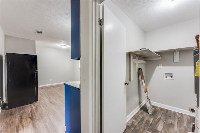 clothes washing area with light wood-style flooring, a textured ceiling, washer hookup, visible vents, and laundry area