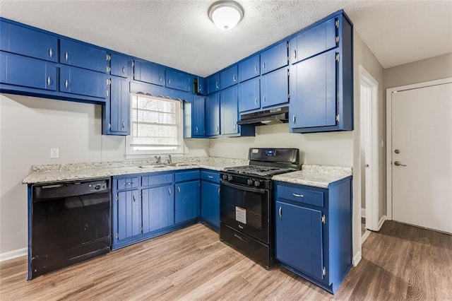 kitchen with light wood-style floors, blue cabinetry, black appliances, under cabinet range hood, and a sink