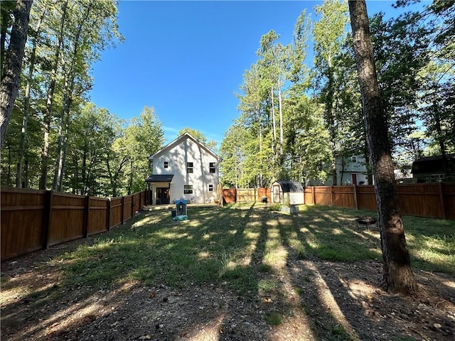 view of yard featuring an outdoor structure, a storage shed, and a fenced backyard