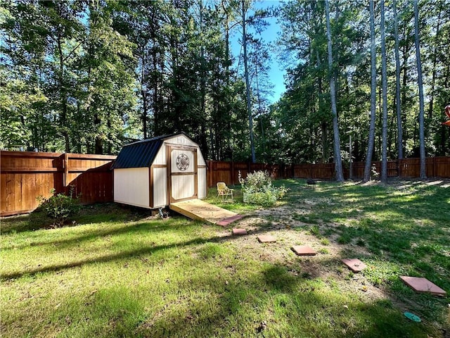 view of yard with a fenced backyard, an outbuilding, and a storage shed