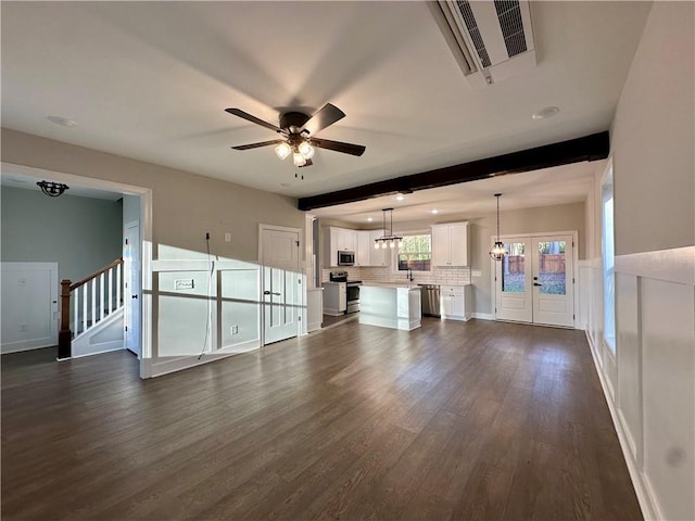 unfurnished living room featuring visible vents, beam ceiling, dark wood finished floors, ceiling fan, and stairs