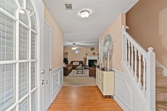 5865 El Segundo Way, Atlanta, GA 30349 - entrance foyer with a textured ceiling, a wainscoted wall, light wood-style flooring, ceiling fan, and stairs