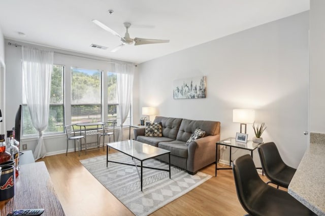 living room with ceiling fan and light wood-type flooring