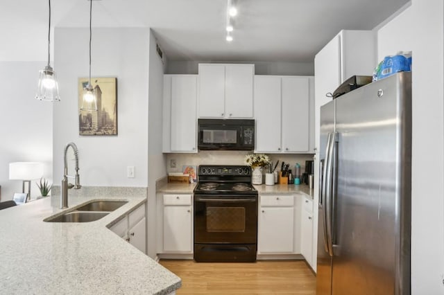 kitchen with sink, decorative light fixtures, white cabinetry, and black appliances