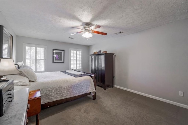 carpeted bedroom with a textured ceiling, baseboards, and a ceiling fan