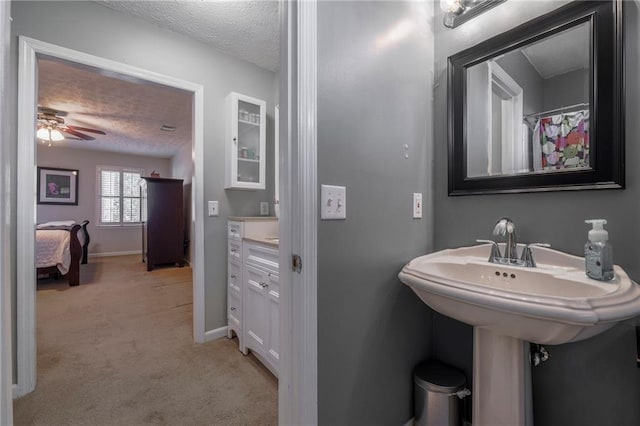 full bath featuring a textured ceiling, baseboards, and a ceiling fan
