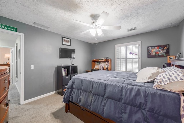 carpeted bedroom featuring baseboards, a textured ceiling, and a ceiling fan