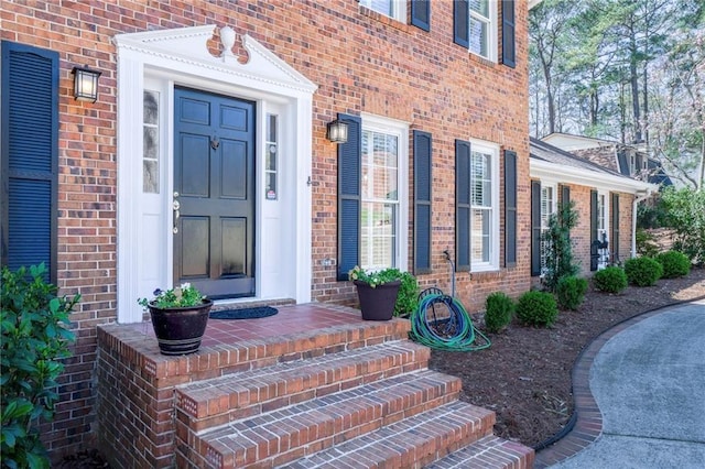 view of exterior entry featuring brick siding