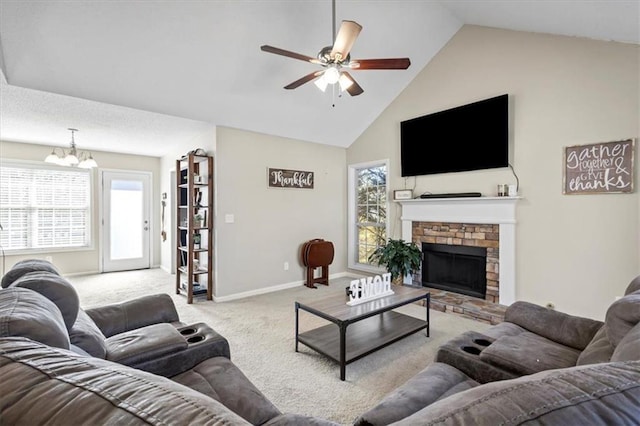 living room with carpet floors, a fireplace with raised hearth, high vaulted ceiling, baseboards, and ceiling fan with notable chandelier