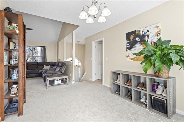 carpeted living area featuring an inviting chandelier and baseboards