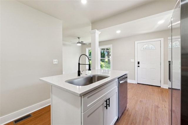 2081 Verbena St NW, Atlanta, GA 30314 - kitchen featuring dishwasher, light wood-style flooring, a center island with sink, a ceiling fan, and white cabinetry