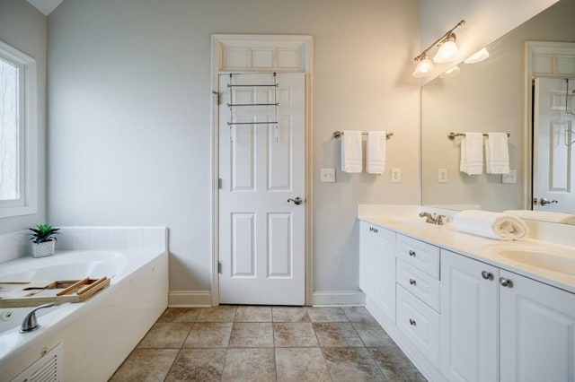 bathroom with vanity, tile patterned floors, a bathing tub, and a healthy amount of sunlight