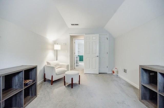 living area featuring lofted ceiling and light colored carpet