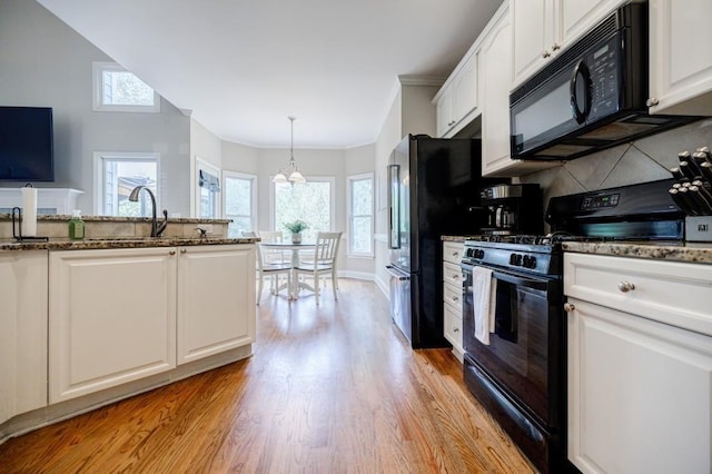 kitchen featuring black appliances, light hardwood / wood-style floors, white cabinets, decorative backsplash, and decorative light fixtures