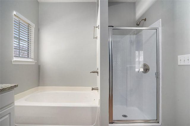 full bath featuring a stall shower, vanity, and a bath