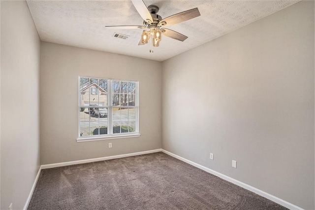 carpeted empty room featuring baseboards, visible vents, and a textured ceiling