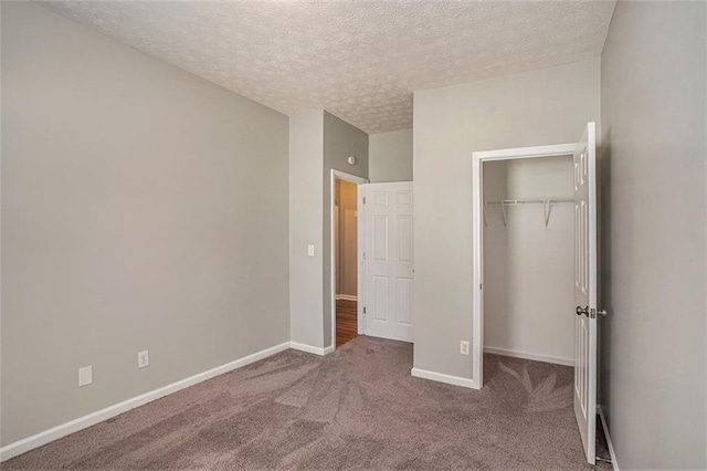 unfurnished bedroom featuring carpet flooring, baseboards, a closet, and a textured ceiling