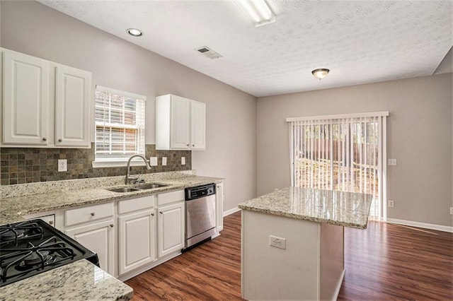 kitchen featuring visible vents, a sink, dark wood-style floors, decorative backsplash, and dishwasher