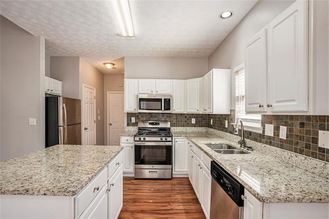 kitchen with a sink, decorative backsplash, dark wood-style flooring, and stainless steel appliances