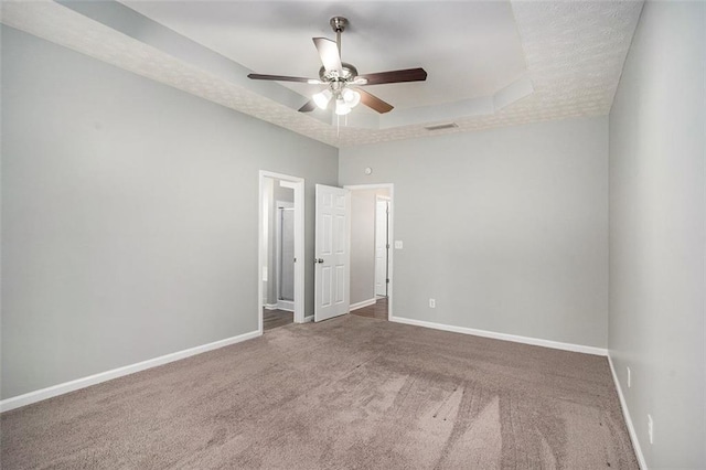 unfurnished room with visible vents, baseboards, and a tray ceiling